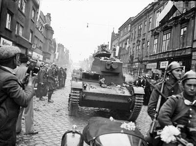 Файл:Wojska pancerne podczas defilady widoczny czołg lekki 7 TP. Z lewej mężczyzna z ręczną kamerą filmową.jpg
