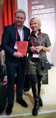 С историком Н. П. Таньшиной на международном форуме «История для будущего. К 100-летию СССР» (23 ноября 2022 года). Держит в руках биографию Антонио Грамши французского историка Жан-Ива Фретинье[фр.]