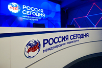 Логотип медиагруппы в международном мультимедийном пресс-центре (фирменный стиль, принятый в 2021 году[1])