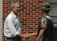 Президент США Джордж Буш выражает благодарность мексиканскому морскому пехотинцу за их работу по очистке Галфпорта, штат Миссисипи, после урагана «Катрина» в 2005 году