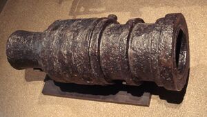 200-килограммовая бомбарда из кованого железа (около 1450 года), Мец, Франция. Состоит из металлических брусков, соединённых горячей ковкой и скреплённых металлическими обручами. Стреляла 6 килограммовыми каменными ядрами. Длина 82 см