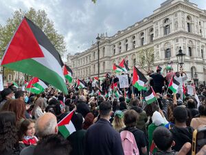 A dense protest with many Palestinian flags flying.