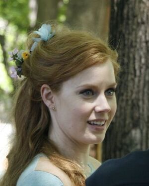 Casual head shot of blue-eyed young woman with long reddish-blond hair pulled back.
