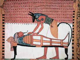 Голова Мафдет в изголовье кровати, на которой лежит мумия Сеннеджема. Обряд совершает Анубис
