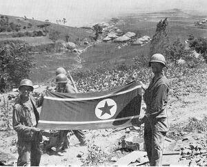 Soldiers hold a North Korean flag