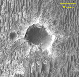 Кратер Бигль, снятый с орбиты аппаратом MRO, камерой выcкого разрешения HiRISE. Маленький кратер слева — кратер Бета