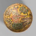Керамическая чаша IX века из Горгана, украшенная накладкой под прозрачной глазурью, изображающая антропную фигуру с головой быка, хранится в Музее исламской эры.