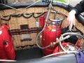 Топливные баки из нержавеющей стали, завёрнутые в красные изолирующие крышки, установленные вертикально и с указателями уровня топлива, во время заправки.