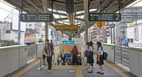 Платформа станции Комагомэ с уложенным тактильным покрытием и установленными автоматическими платформенными воротами.
