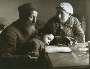 Вольф Нахович, могильщик, учит внука читать, бабушка наблюдает. Бяла-Подляска. 1926