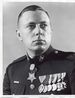 A black and white image of McGinty wearing his military dress blue uniform with medals and no hat. His Medal of Honor is visible around his neck.