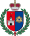 A coat of arms depicting a grey castle on a red background on the left and a blue eye in a yellow triangle on the right