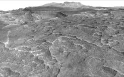 Характерный фестончатый рельеф[en], побудивший исследователей проверить присутствие подповерхностного льда. Зубчатые образования имеют в ширину 100-200 м. Передний план изображения охватывает область протяжённостью 1,8 км. Перспектива сформирована посредством трёхмерной модели ландшафта, полученного стереокамерой HiRISE на аппарате «Mars Reconnaissance Orbiter» с 25 декабря 2006 года по 2 февраля 2007 года.