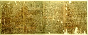 Фрагментированный папирус с немного порванными краями и иератическим почерком в красных чернилах