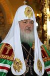 Патриарх всея Руси Кирилл в белом каптыре с крестом наверху
