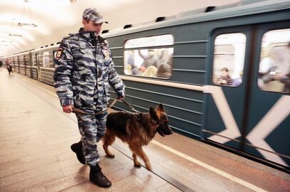 Полицейский-кинолог с собакой во время осмотра станции на наличие подозрительных предметов
