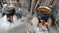 Два металлических горшка с пальмовым маслом в процессе изготовления