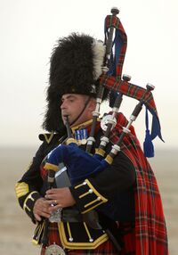 Военнослужащий Королевского шотландского драгунского гвардейского полка играет на великой хайлендской волынке в Басре во время проведения операции «Телик 12». 22 августа 2008.