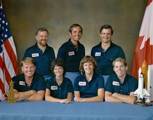 внизу слева-направо, — астронавты: Джон Макбрайд (пилот); Салли Райд, Кэтрин Салливэн и Дэвид Листма (специалисты полёта). Наверху, также слева-направо: Пол Скалли-Пауэр (специалист по полезной нагрузке), Роберт Криппен (командир экипажа) и Марк Гарно (канадский специалист по полезной нагрузке)