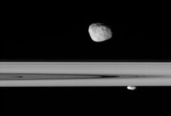 Янус (выше) и Прометей (ниже) на фоне колец Сатурна
