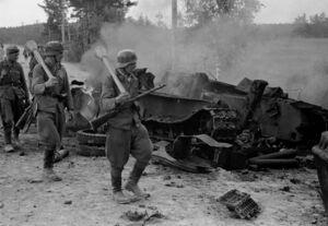 Пехотинцы 12 полка идут мимо уничтоженного танка Т-34 30 июня 1944.