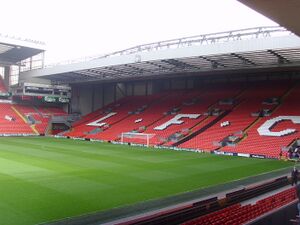 The end of a football stadium with th seats painted red.