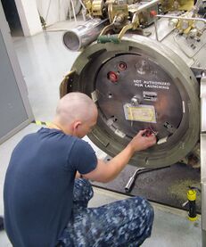 US Navy 091112-N-9531K-004 Fireman Recruit Patrick Todd, a student at Basic Enlisted Submarine School, uses the Torpedo Tube Trainer to learn how to load Tomahawk cruise missile.jpg