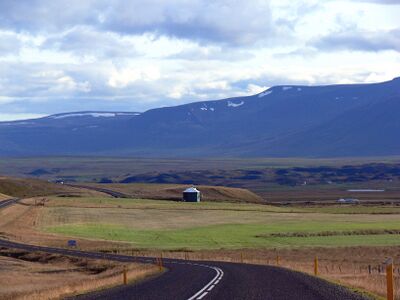 Холмы, поля и ферма в низменности Исландии