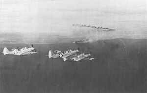 Бомбардировщики союзников Douglas TBD Devastator готовятся напасть на японский флот в заливе Хуон 10 марта 1942 года. На снимке также видны два японских корабля, пустивших дымовую завесу в попытке скрыть себя от надвигающейся атаки с воздуха.